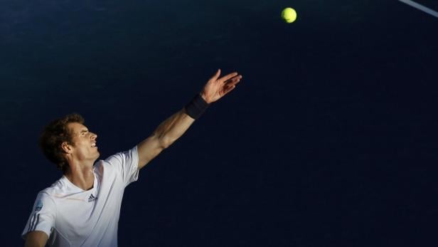 Ein Tennisspieler wirft einen Ball zum Aufschlag hoch.