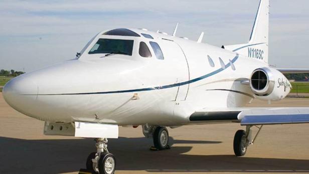 Ein weißes Privatflugzeug steht auf einer Startbahn.