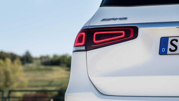 Detailansicht des Rücklichts und des AMG-Logos eines weißen Autos.