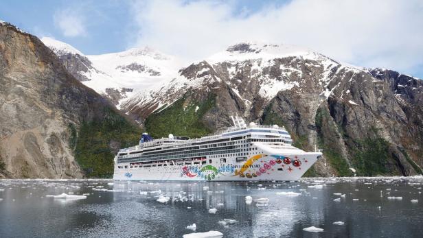 Die „Norwegian Pearl“ kreuzt vor einer Bergkulisse mit Schnee und Eis.