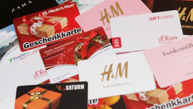 Verschiedene Geschenkkarten von Händlern wie H&M, Media Markt, Thalia, Saturn und s.Oliver liegen übereinander.