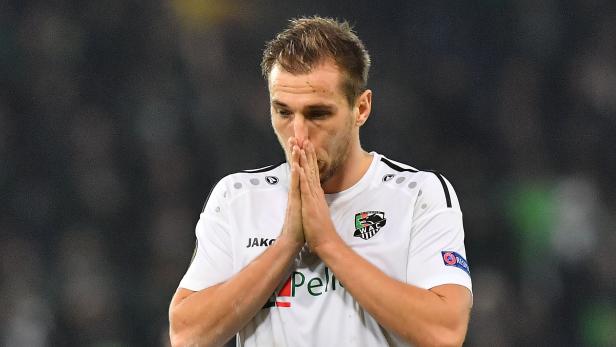 Ein Fußballspieler des Wolfsberger AC mit gesenktem Kopf und gefalteten Händen.