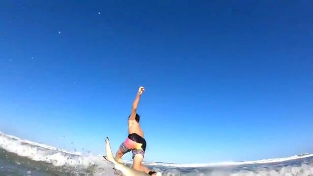 Ein Screenshot des Videos, das zeigt, wie der siebenjährige Chandler Moore von einem Hai von Surfbrett gestoßen wird.