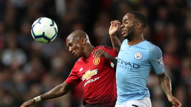 Zwei Fußballspieler kämpfen um den Ball während eines Spiels.