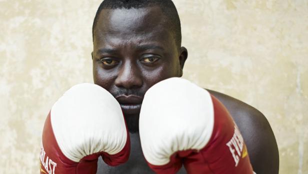 Ein Boxer mit roten Boxhandschuhen in Kampfposition.