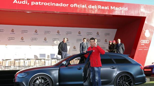 Cristiano Ronaldo posiert vor einem grauen Audi mit geöffneter Tür.