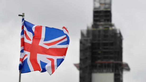 A Union Jack flag flutters as Big Ben clock tower is seen behind at the Houses of Parliament in London