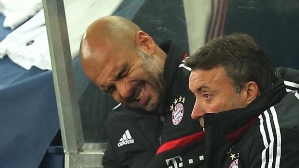 Pep Guardiola lacht auf der Bank des FC Bayern München.
