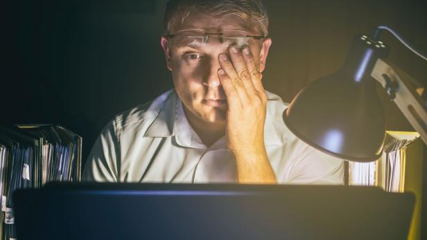 Man with tired eyes due to too much work on the computer screen