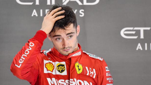 Charles Leclerc im roten Ferrari-Rennanzug mit der Hand im Haar.