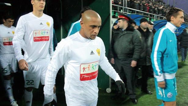 Fußballspieler betreten den Rasen durch einen Tunnel.