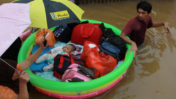 Ein Baby wird im Scbhlauchboot gerettet