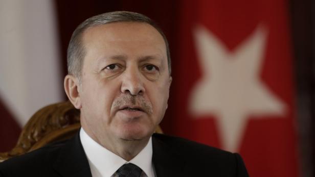 Ein Porträt von Recep Tayyip Erdoğan vor türkischen Flaggen.