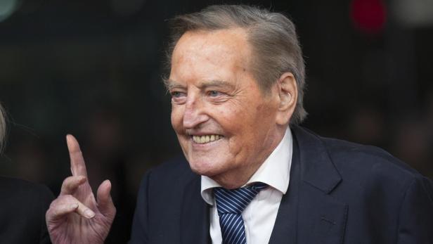 William Shatner lächelt und hebt einen Finger.