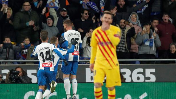 Jubelnde Espanyol-Spieler und enttäuschte Barcelona-Spieler während eines La Liga Santander Spiels.