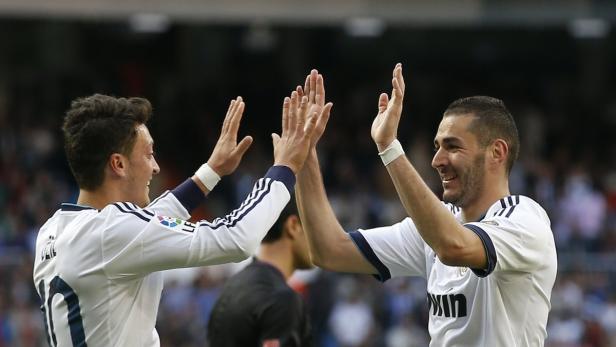 Real Madrid&#039;s Karim Benzema celebrates a goal with teammate Mesut Ozil (L) during their Spanish First Division soccer match against Real Betis at Santiago Bernabeu stadium in Madrid April 20, 2013. REUTERS/Juan Medina (SPAIN - Tags: SPORT SOCCER)