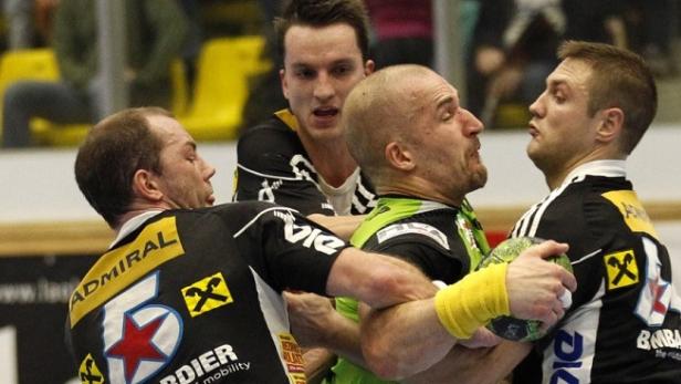 Handballspieler kämpfen um den Ball während eines Spiels.