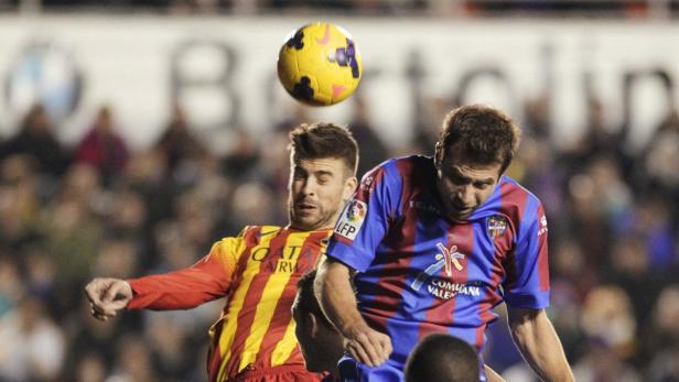 Zwei Fußballspieler kämpfen um einen gelben Ball in der Luft.