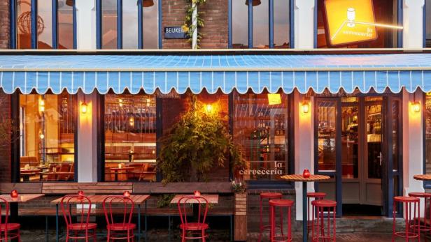 Das „La Cerveceria“ Lokal mit blau-weiß gestreifter Markise und roten Stühlen vor der Tür.