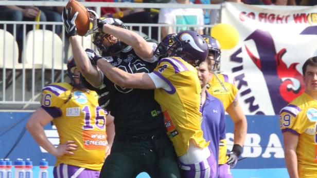 Zwei American-Football-Spieler kämpfen um den Ball.