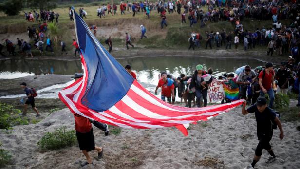 Migrants, mainly from Central America, marching in a caravan walk after crossing the Suchiate river, on the outskirts of Ciudad Hidalgo