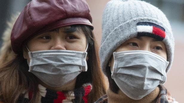 Mundschutzmasken tragen asiatische Touristen bei ihrem Besuch der Innenstadt von Frankfurt.