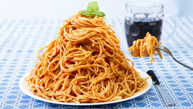 Huge Pile Of Spaghetti On Plate and Twirled Around Fork