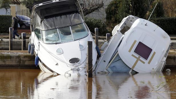 Zwei gekenterte Boote liegen im trüben Wasser eines Kanals.