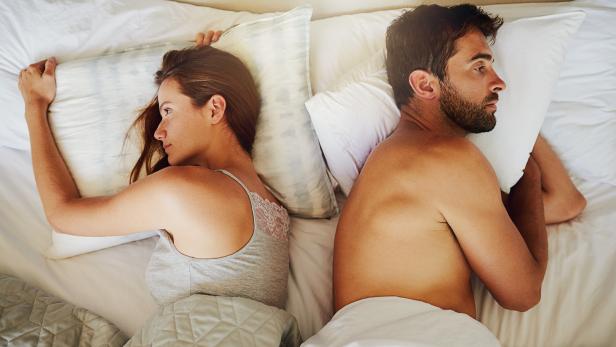 Ein Paar liegt im Bett und verzichtet auf Geschlechtsverkehr