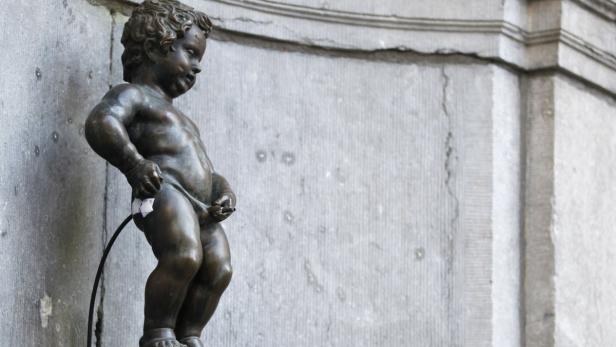Die Bronzestatue des Manneken Pis in Brüssel uriniert.