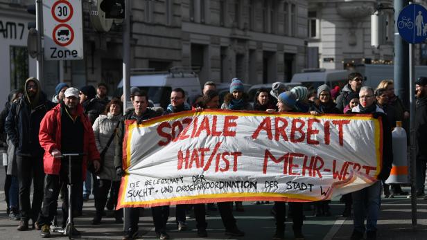 Eine Gruppe von Menschen demonstriert mit einem Banner für „Soziale Arbeit hat/ist Mehr-Wert“.