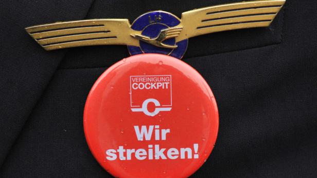 Ein Lufthansa-Pilotenabzeichen und ein Button mit der Aufschrift „Wir streiken!“.