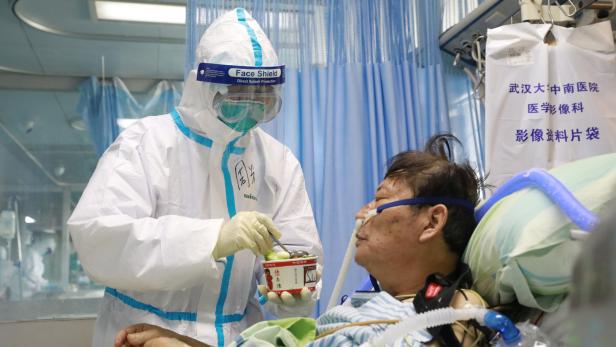 Eine Krankenschwester gibt einem schwer Erkrankten Essen an der Uni-Klinik von Wuhan: 80 Prozent der Infektionen verlaufen aber mild.