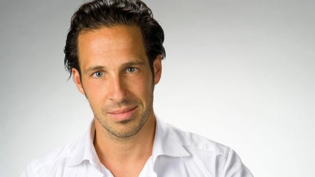 Porträt eines Mannes mit dunklen Haaren und einem weißen Hemd.