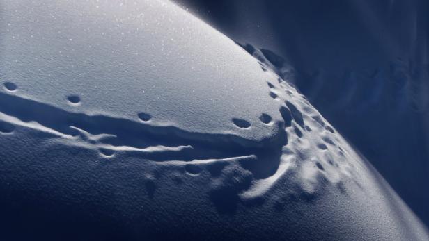 Nahaufnahme von Fußspuren im Schnee.