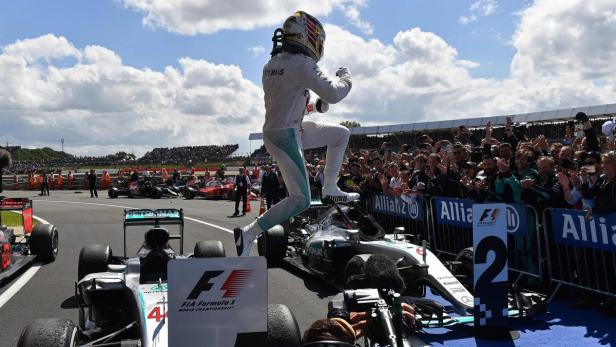 Mercedes AMG Petronas F1 Team&#039;s British driver Lewis Hamilton jumps from his car after winning the British Formula One Grand Prix at Silverstone motor racing circuit in Silverstone, central England, on July 10, 2016. / AFP PHOTO / ANDREJ ISAKOVIC