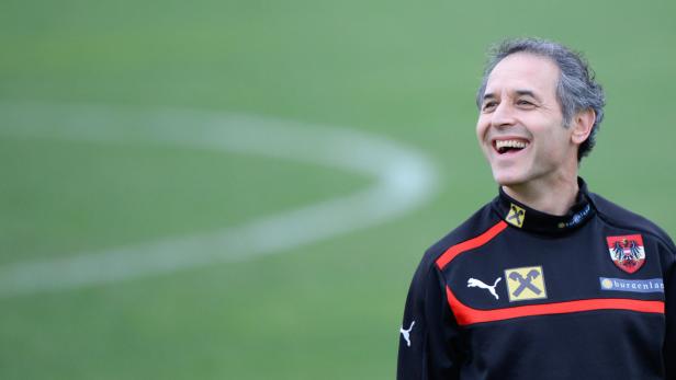 Ein lachender Mann in Trainingskleidung des österreichischen Fußballteams.