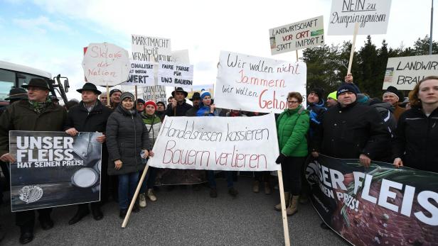 Bauern demonstrieren mit Schildern gegen Dumpingpreise und für faire Bedingungen.