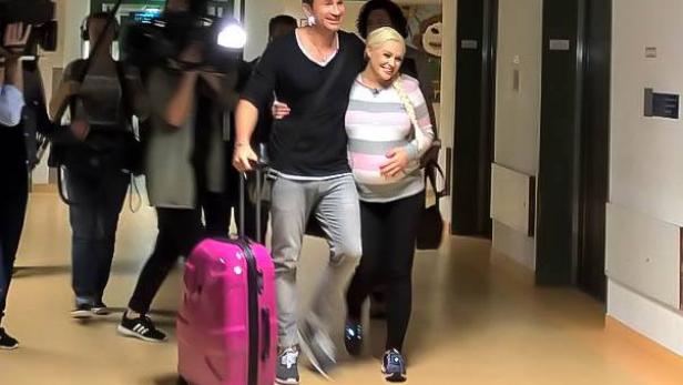 Daniela Katzenberger und Lucas Cordalis verlassen mit einem pinken Koffer ein Krankenhaus.