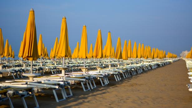 the yellow umbrellas still closed and the deckchairs still to be opened