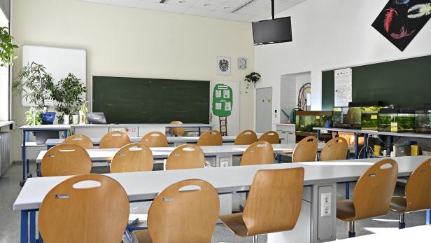 Ein Klassenzimmer mit Tischen, Stühlen und Aquarien.
