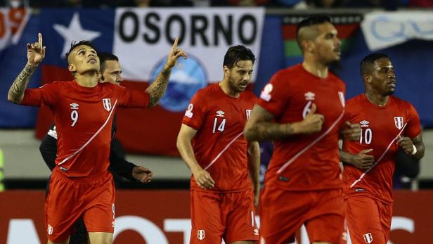 Mehrere peruanische Fußballspieler in roten Trikots während eines Spiels.