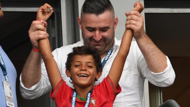 Cristiano junior ist umringt von Bodyguards, als er seinen Papa von der Tribüne aus anfeuert.