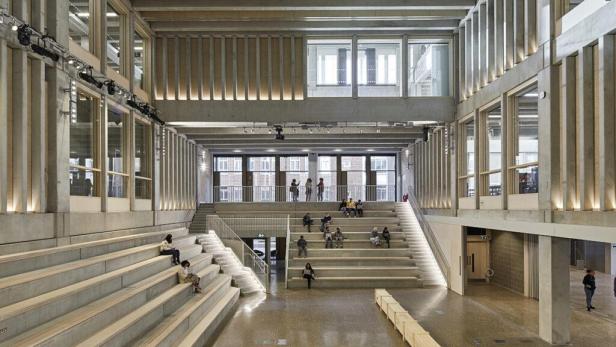 Menschen sitzen auf den Stufen im Town House der Kingston University.