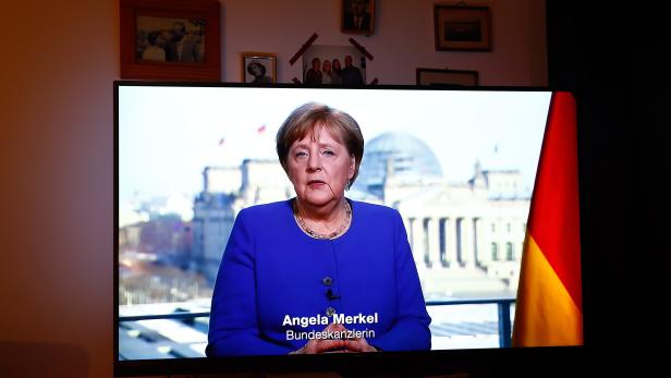 Family Bruhn watches German Chancellor Angela Merkel on television in Berlin