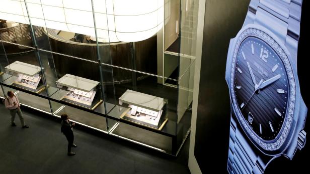 Visitors walk past the exhibition stand of Swiss watch manufacturer Patek Philippe at the Baselworld watch and jewellery fair in Basel