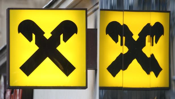 Zwei gelbe Schilder mit dem schwarzen Logo der Raiffeisen Bank.