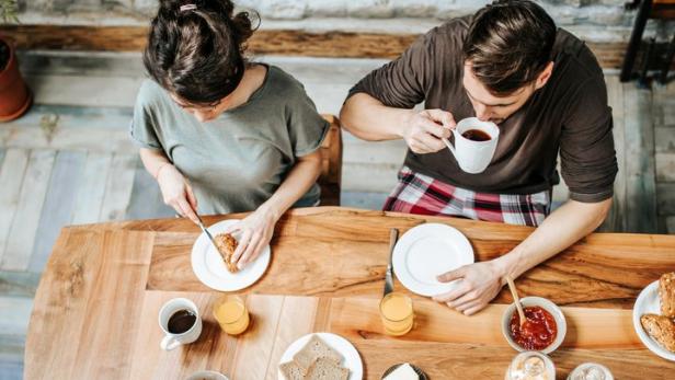 High angle view of a family eating their breakfast together at dining table.