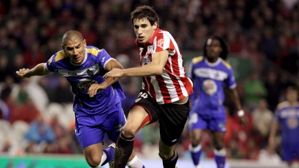 epa02423172 Athletic Bilbao&#039;s midfielder Javier Martínez (R) fights for the ball with Getafe&#039;s defender Daniel Alberto Díaz &quot;Cata&quot; (L) during their Spanish Primera Division soccer match held at San Mames stadium, in Bilbao, northern Spain, 31 October 2010. EPA/LUIS TEJIDO