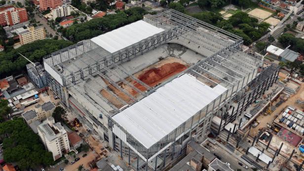 Luftaufnahme eines Stadions im Bau, umgeben von Stadtgebiet.